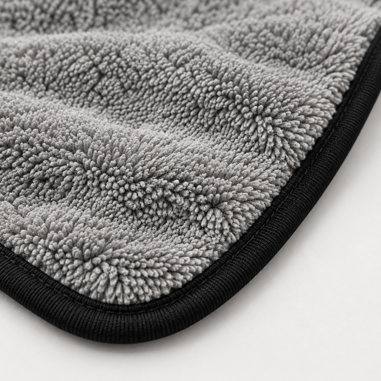 Gros plan de la microfibre grise et de la bordure noire de la serviette Reflet Auto XL.
