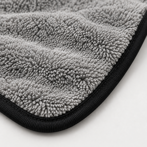 Gros plan de la microfibre grise et de la bordure noire de la serviette Reflet Auto XL.