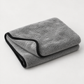 Une serviette microfibre Reflet Auto XL grise à bordure noire, pliée sur un fond clair.