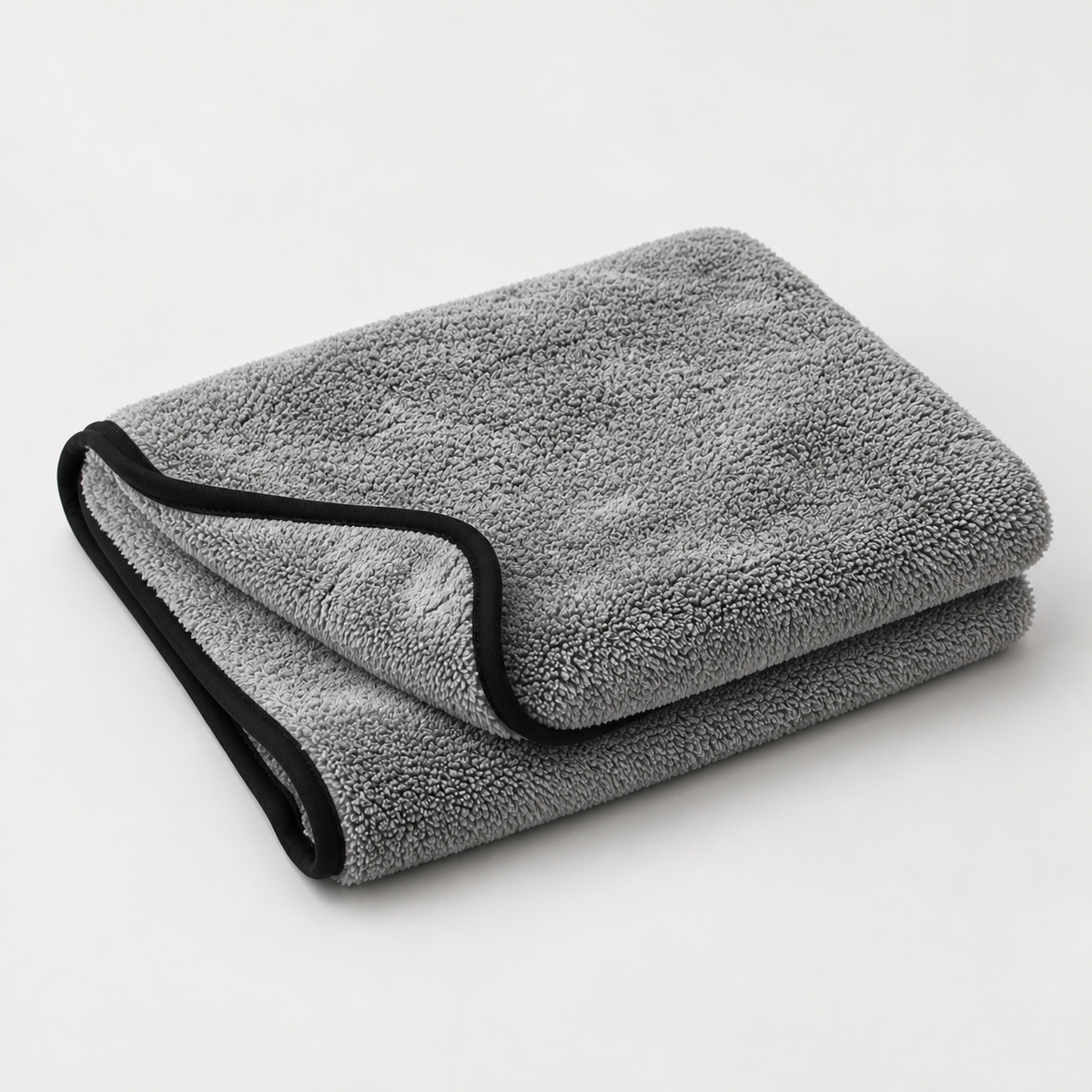 Une serviette microfibre Reflet Auto XL grise à bordure noire, pliée sur un fond clair.