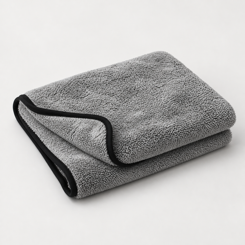 Une serviette microfibre Reflet Auto XL grise à bordure noire, pliée sur un fond clair.